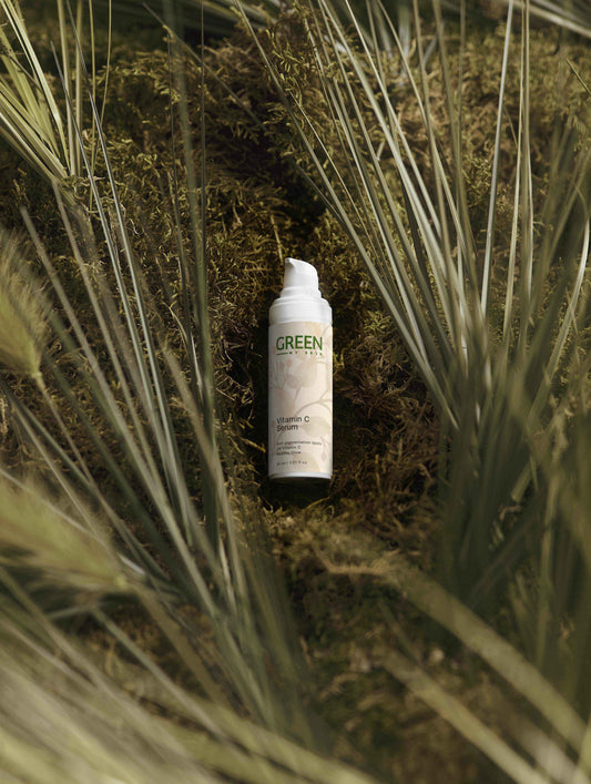 Fade Away Dark Spots: A Guide to Vitamin C Serums and Moisturizers for Hyperpigmentation on a green background.