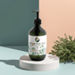 Hydrating hand-body wash with patchouli, amber vanilla scent in a botanical background.