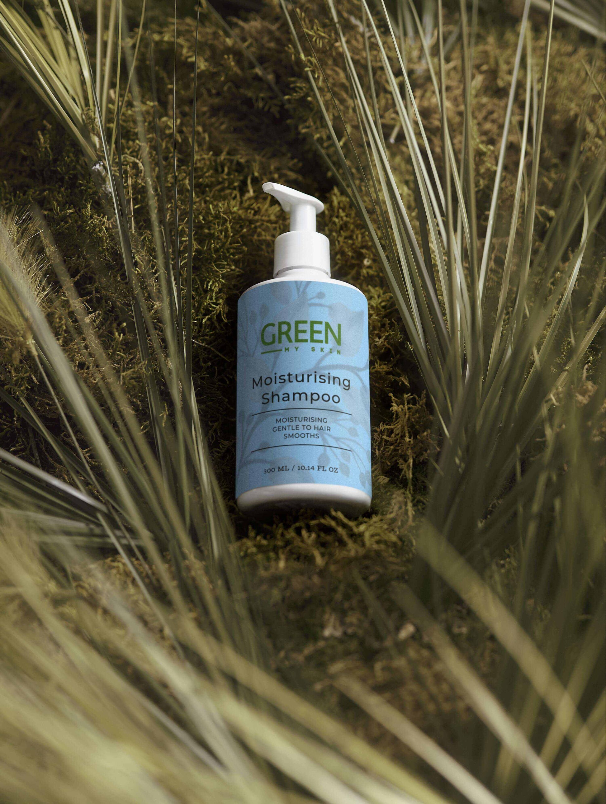 Gentle Moisturising Shampoo bottle nestled among green plants, ideal for daily hair care.