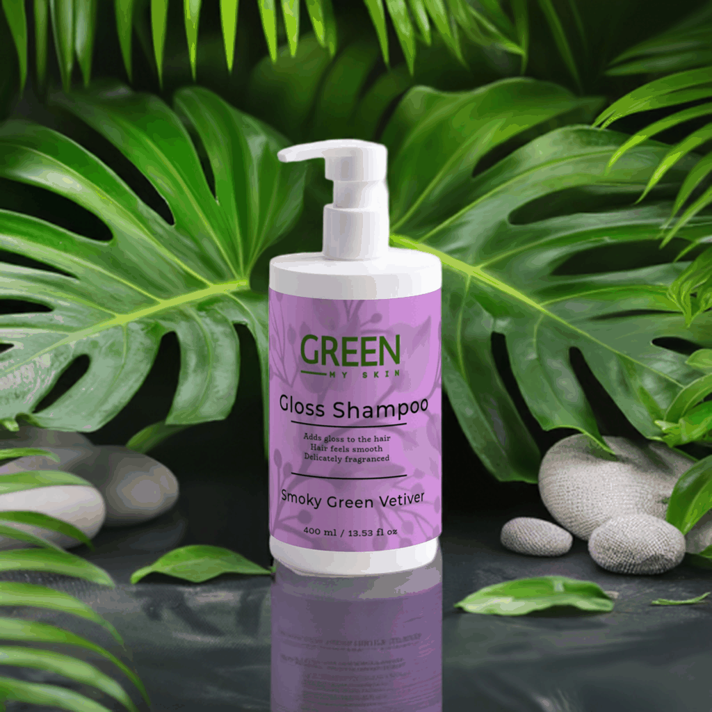 Gloss-shampoo bottle with smoky green vetiver surrounded by lush green leaves and stones.