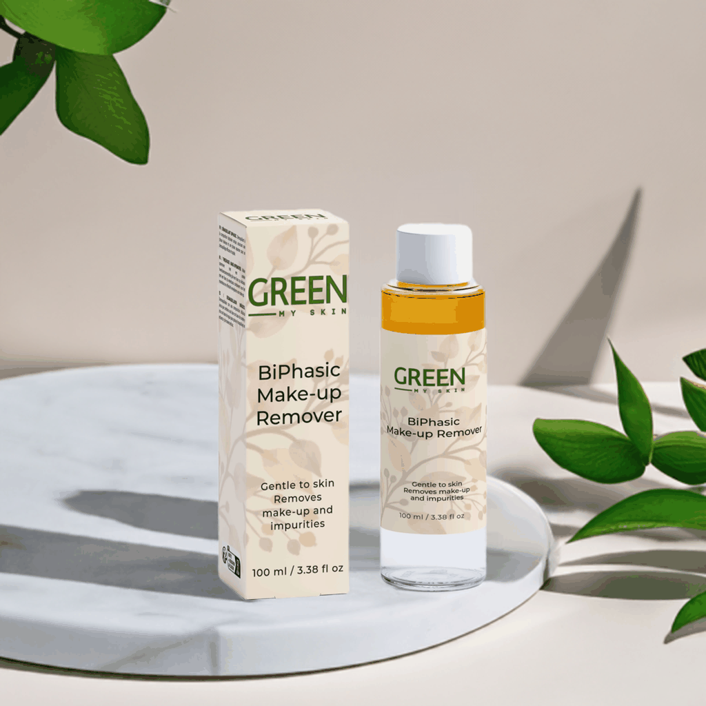 BiPhasic make-up remover bottle and box on a marble surface surrounded by green leaves.