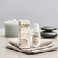 Double Hydration Boost Gel bottle and packaging on a soft fabric with a candle and stones in the background.