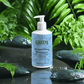 Gentle moisturising shampoo bottle surrounded by lush green foliage, emphasizing natural care.